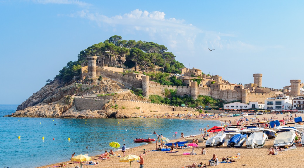 A view of the ancient fortress of Tossa de Mar, in the foreground beach.
